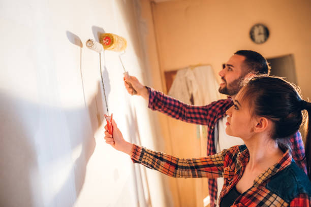 istock Young couple painting wall 1168327889