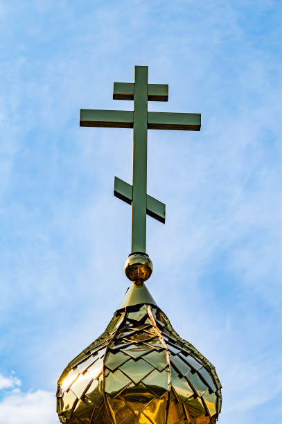 cupole dorate con una croce della chiesa ortodossa dell'ucraina su uno sfondo di cielo blu. - kyiv orthodox church dome monastery foto e immagini stock