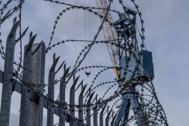 istock Fencing, razor wire and a crane at a shipyard 1168328940