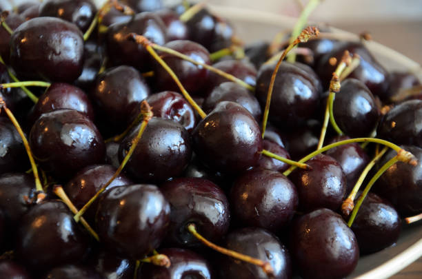 istock Wet chilled cherries with peduncles on plate on table 1168334232