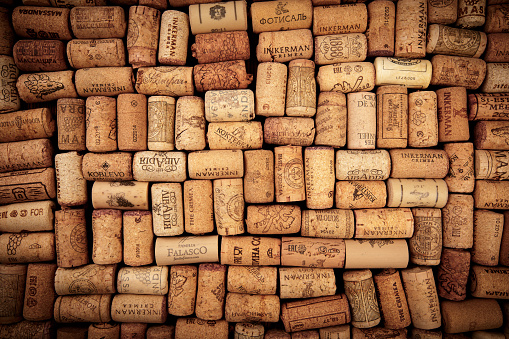 Closeup pattern background of many different wine corks with dates and drops of wine