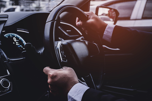 closeup Man hand wearing a suit, driving a car
