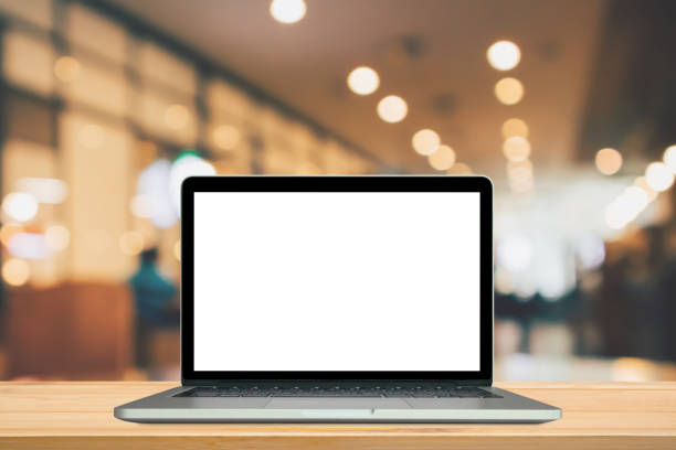 istock Blank white screen laptop computer on wood table top with cafe restaurant abstract bokeh light defocused blur background 1168336313
