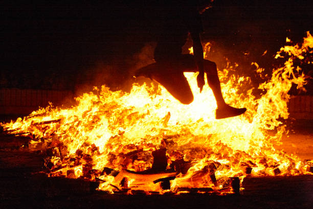 Summer solstice celebration in Spain. Woman jump. Fire flames Summer solstice celebration in Spain. Woman jump. Fire flames. Horizontal san juan stock pictures, royalty-free photos & images