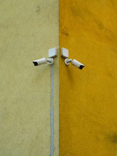 Cameras placed on the corner of the building. Control and monitoring system. Bright, dirty background.