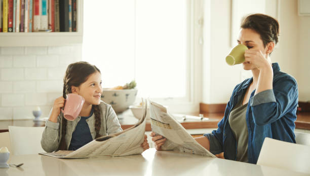 она хочет быть такой же, как ее мама - newspaper reading mother women стоковые фото и изображения