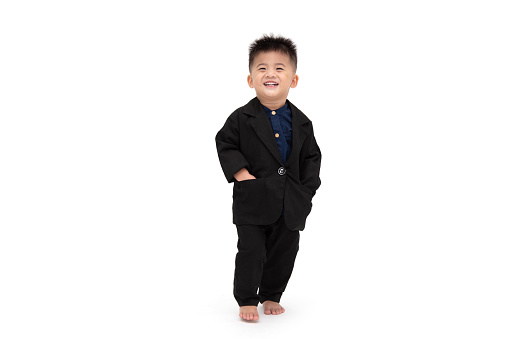 Cute Asian boy smiling and standing with black suit isolated on white background, 1 year 10 month old