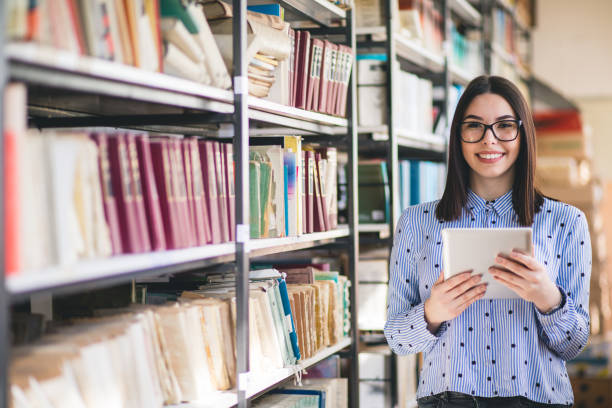 istock Portrait of college student studying in the library using tablet PC 1168339943