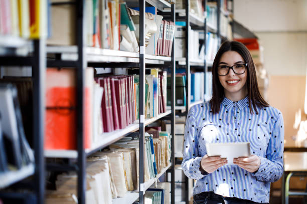 istock Portrait of college student studying in the library using tablet PC 1168340050