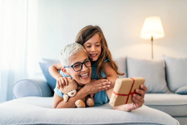 gift from granny - grandmother giving gift child imagens e fotografias de stock