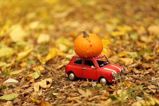 Autumn concept. Thanksgiving. Pumpkin by car.red decorative car carries an orange pumpkin. Pumpkin delivery. Fall season. Autumn concept. Thanksgiving. Pumpkin by car.red decorative car carries an orange pumpkin. Pumpkin delivery. Fall season. thanksgiving holiday travel stock pictures, royalty-free photos & images