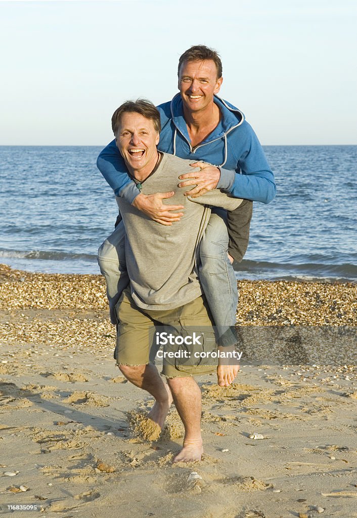 Felice coppia gay sulla spiaggia. - Foto stock royalty-free di Coppia gay