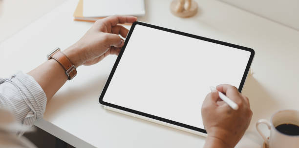 istock Top view of man using blank screen tablet in minimal office 1168351637
