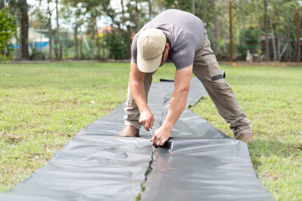istock Handyman cutting black garden plastic 1168352898