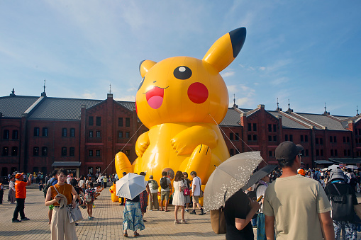 Yokohama, Kanagawa Prefecture, Japan - August 12, 2019: Pikachu Outbreak event at Red Brick Warehouse. A giant inflatable Pikachu displayed on the square. Many people from all over the world enjoy the event.