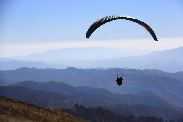 istock flying paraglider over valley in mountains 1168354460
