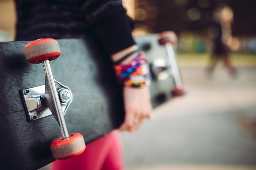 Young caucasian woman with skateboard in hands.