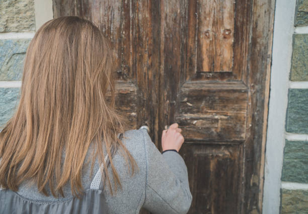 istock Woman opening very old wooden door. 1168356609
