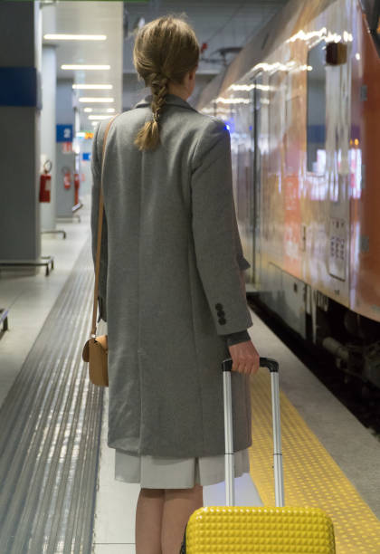 istock Business lady is waiting for a train at the station. 1168356810