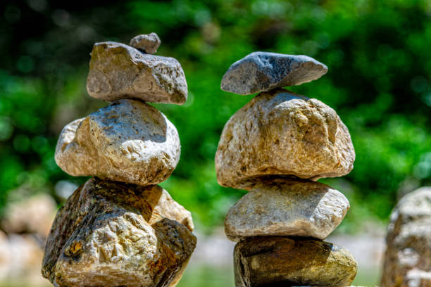 pierres empilées à côté d'un lac de montagne - canada alberta mountain mountain range photos et images de collection