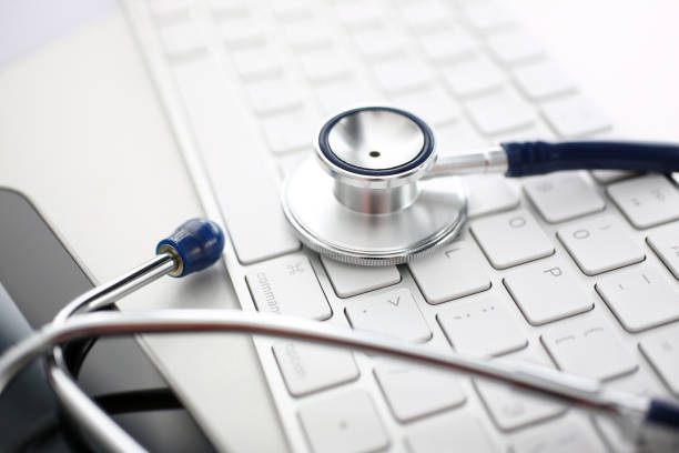 istock Medical stethoscope head lying on silver keyboard at doctor office worktable 1168360808
