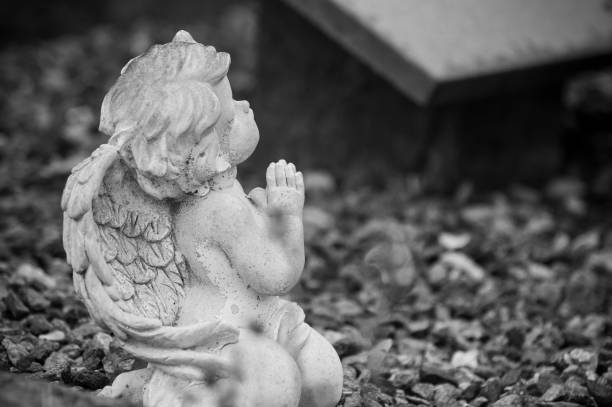 istock stoned angel praying on tomb in cemetery 1168361544