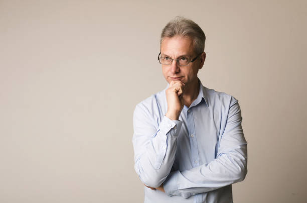 istock Thoughtful mature man holding hand on chin 1168361600