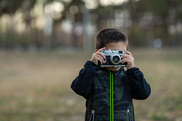 istock toddler boy with old retro vintage camera 1168363863