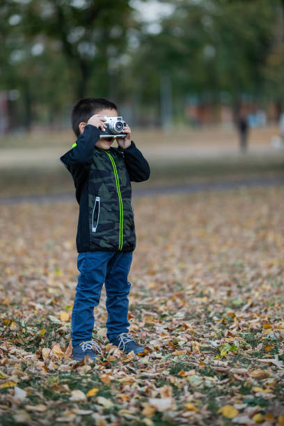 istock toddler boy with old retro vintage camera 1168363900