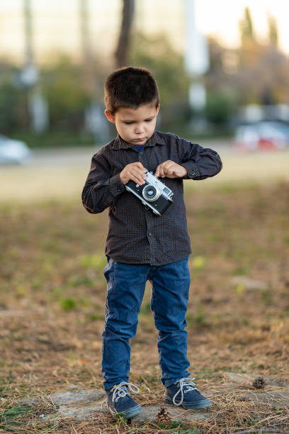 istock toddler boy with old retro vintage camera 1168364003