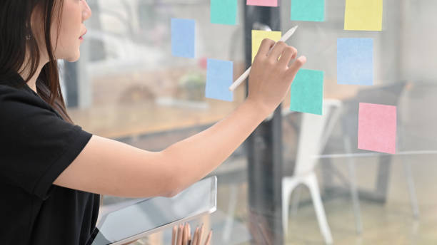 istock Sticky note paper reminder young woman share idea on sticky note. Discussing - business. 1168364022