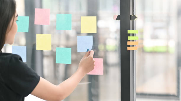 istock Sticky note paper reminder young woman share idea on sticky note. Discussing - business. 1168364041