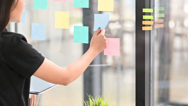 istock Sticky note paper reminder young woman share idea on sticky note. Discussing - business. 1168364109