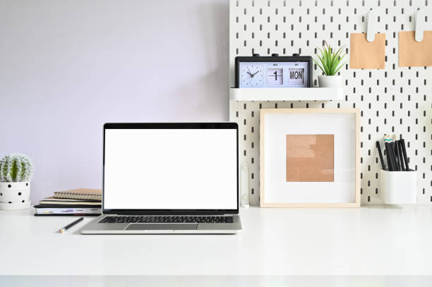 istock Workspace laptop, pegboard and office supplies on white table office. 1168364152