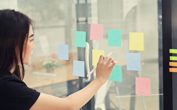 istock Sticky note paper reminder young woman share idea on sticky note. Discussing - business. 1168364153