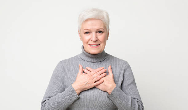 istock Kind senior woman keeping both palms on chest 1168365694