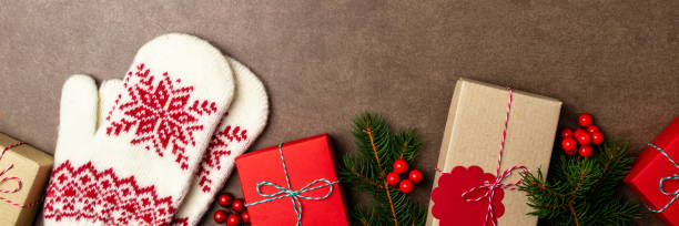 istock Christmas background with gift box, christmas tree, mittens and decorations on stone background. Top view 1168366591