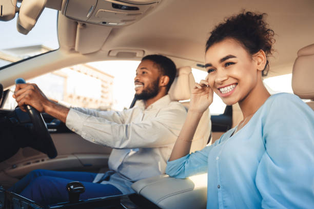 felice di viaggiare insieme. coppia afro-americana alla guida in auto - chasing women men couple foto e immagini stock