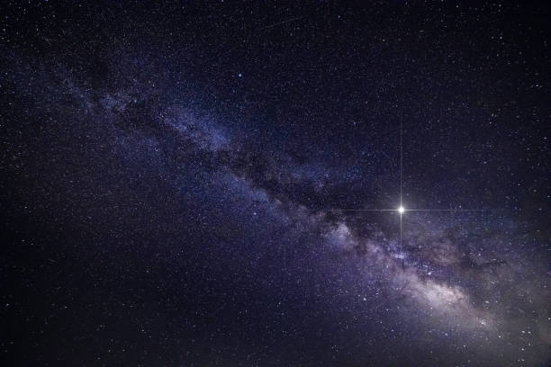 istock Abstract background with spike glowing lucky star and Milky Way Galaxy during clear summer night - creative stock image 1168368021