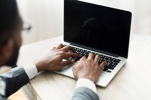 istock African businessman typing on laptop with black blank screen 1168368204