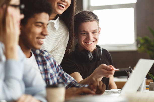 International students looking at laptop in school