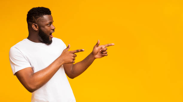 istock Excited black man pointing two fingers aside at copy space 1168368291