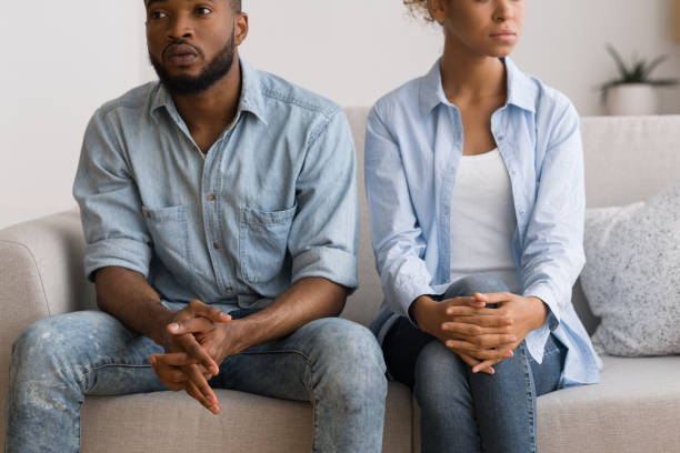 istock Black Couple Avoiding Eye Contact After Quarrel Sitting On Couch 1168368944