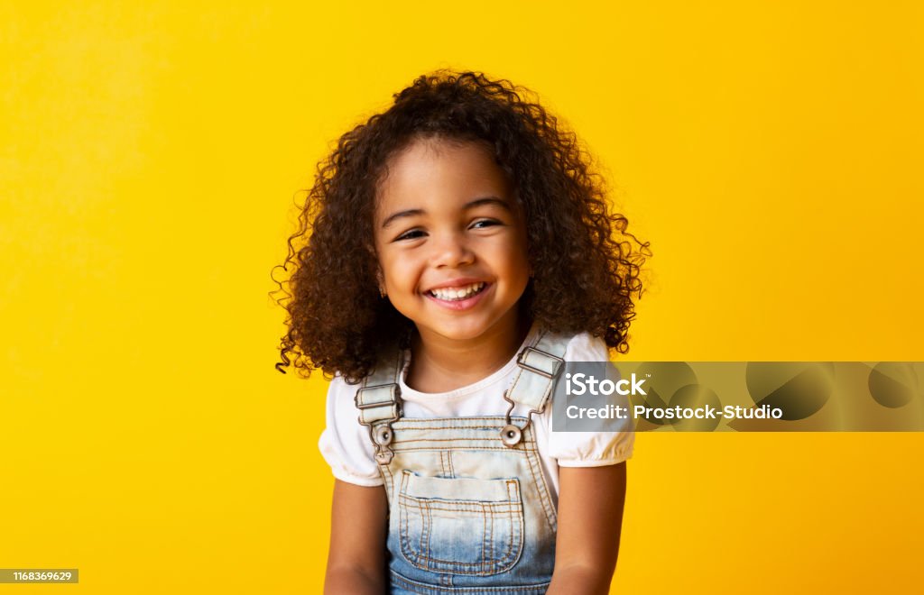Menina Africana-Americana de sorriso feliz da criança, fundo amarelo - Foto de stock de Criança royalty-free
