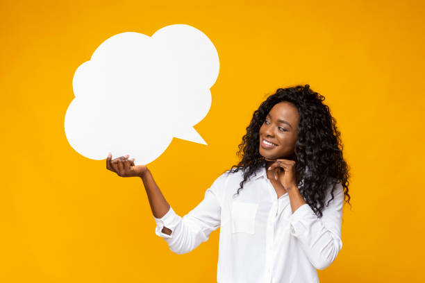 istock Playful afro girl looking at communication bubble in her hand 1168371240