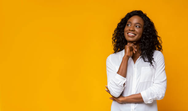istock Young afro girl dreaming on yellow background 1168371307