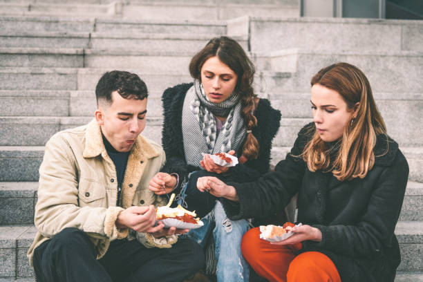 istock three young travellers having curry sausage outdoors in Berlin 1168371387