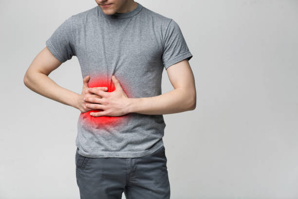 istock Man in pain holding his stomach on right side 1168371684