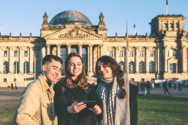 istock three young people looking at mobile in front of Berlin Reichstag 1168371716