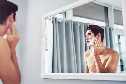 Shot of a handsome young man applying shaving cream to his face